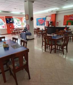 een eetkamer met houten tafels en stoelen bij Hotel el Mayo Inn in Culiacán