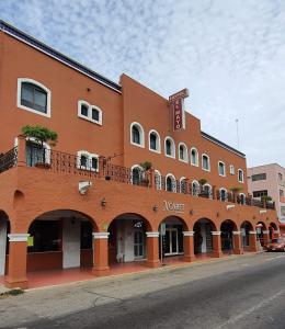 een groot oranje gebouw met een balkon in een straat bij Hotel el Mayo Inn in Culiacán