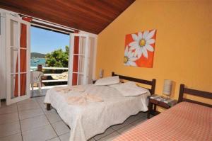 a bedroom with a bed and a view of the ocean at Meu Sonho Búzios in Búzios