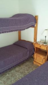 1 dormitorio con 2 literas y mesa en Cabañas Alma Comechingon en Villa Cura Brochero
