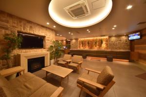 a lobby with a fireplace and a waiting room at Dormy Inn Premium Sapporo in Sapporo