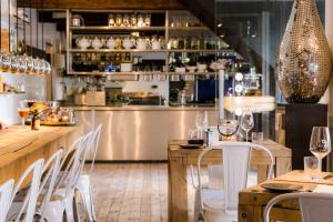 a restaurant with a bar with white tables and chairs at Houseboat Martinique in Maastricht