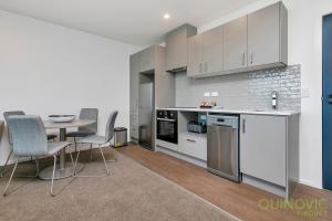 a kitchen and dining room with a table and chairs at QV City Central with Carpark (906) in Auckland