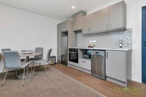 a kitchen and dining room with a table and chairs at QV Stays City Central Apartment with Parking in Auckland