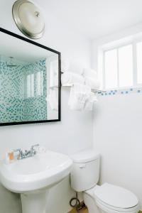 a bathroom with a white toilet and a mirror at Aqua Hotel & Suites in Miami Beach