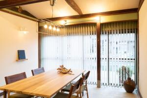 a dining room table with chairs and a large window at MINKA Riverside Villas in Shimminato +30 photos