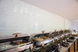 a row of trays of food in a kitchen at Kokotel Khao Lak Lighthouse in Khao Lak