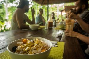 a bowl of food on a wooden table with people sitting around it at Chirapa Manta Amazon Lodge in Lamas