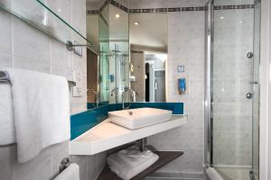 
a bathroom with a shower, sink, and toilet at Holiday Inn Express London Greenwich, an IHG Hotel in London
