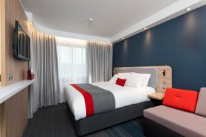 
a bedroom with a large bed and a large window at Holiday Inn Express London Greenwich, an IHG Hotel in London
