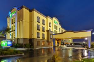 a hotel exterior at night with a parking lot at Holiday Inn Express San Francisco Airport North by IHG in South San Francisco