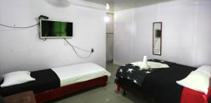 um quarto com 2 camas e uma televisão de ecrã plano em Cabinas El Muellecito em Tortuguero