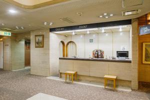 a restaurant with a counter and two stools in a building at Dai-ni Sunny Stone Hotel in Osaka