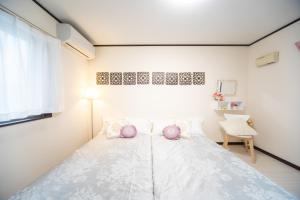 1 dormitorio con 1 cama grande con almohadas moradas en Awaji Central Inn Kuruma713 en Awaji