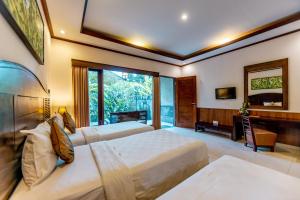 Postel nebo postele na pokoji v ubytování De Munut Balinese Resort