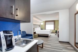 a kitchen with a sink and a room with a bed at Holiday Inn Express Hotel & Suites Clewiston by IHG in Clewiston +18 photos