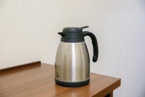 a tea kettle sitting on a wooden table at Dai-ni Sunny Stone Hotel in Osaka