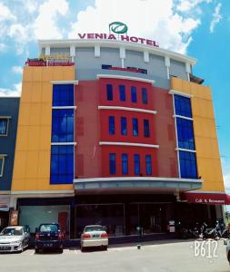 Sagulung的住宿－Venia Hotel Batam - CHSE Certified，前面有汽车停放的建筑