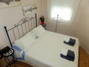 1 dormitorio con 1 cama blanca y 2 toallas en Esencia de Sevilla, en Sevilla