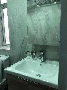 香港的住宿－New hoover hostel，一间带水槽、镜子和卫生间的浴室