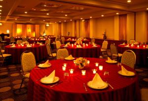 a banquet hall with red tables and chairs with candles at Nest Hotel Sapporo Ekimae in Sapporo