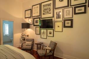 een slaapkamer met een muur van ingelijste foto's en een tv bij Hawthorne House in Hastings