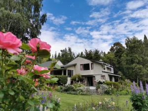 una casa con flores rosas en el patio en Star Dream Manor, en Lake Tekapo