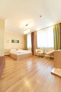 een grote kamer met een bed en een bank bij Hotel Merkuriy in Lviv