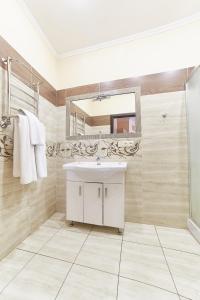 y baño con lavabo blanco y espejo. en Hotel Merkuriy, en Leópolis