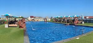 a pool at a resort with people playing in it at Sulis Beach Hotel & Spa in Kuta
