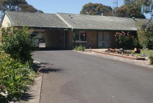 ein Backsteinhaus mit einer Einfahrt davor in der Unterkunft Peppinella Motel in Ballarat