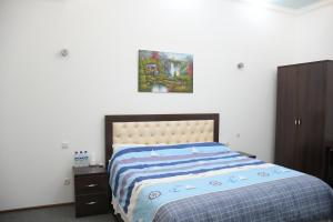 a bedroom with a bed and a painting on the wall at Nurziyo Guest House in Tashkent