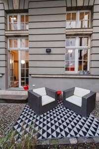 zwei Stühle auf einem karierten Boden vor einem Haus in der Unterkunft LE-Style! Top-Galerie-Studio Bauhaus-Stil in Leipzig
