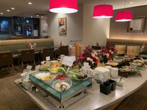 a buffet of food on a table in a restaurant at Sotetsu Fresa Inn Higashi Shinjuku in Tokyo