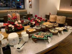 a table with a buffet of food and flowers at Sotetsu Fresa Inn Higashi Shinjuku in Tokyo