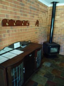 a stove in a room with a brick wall at Busselton Beachfront in Busselton
