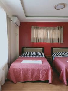 una camera con due letti e pareti rosse di Villa Cresenciana a Batuan
