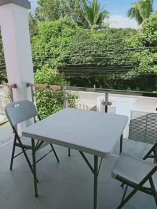 Villa Cresenciana في Batuan: طاولة بيضاء و كرسيين على شرفة
