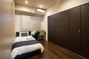 1 dormitorio con cama y escritorio. en Ocean Resort 101 B32, en Shioya