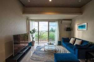 uma sala de estar com um sofá azul e uma grande janela em Ocean Resort 101 B32 em Shioya