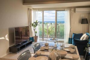 a living room with a table and a view of the ocean at Ocean Resort 101 in Shioya