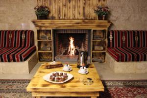a table with a plate of food in front of a fireplace at Reston Hotel in Jounieh