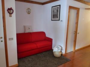 a red couch in a living room with a door at Grangesises 4 posti letto in Sauze di Cesana