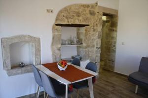 a dining room with a table and some blue chairs at Vafis Apartment at Sivas Village in Sívas