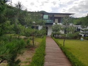 a house with a walkway in front of it at Solnanggu Pension in Gapyeong