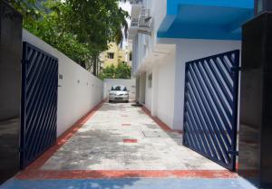 an alley with two blue gates and a car parked on a street at Cloud Nine Serviced Apartments in Chennai