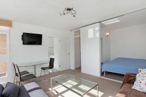 a living room with a couch and a glass table at Central apartment 5 mins Putney tube station in London
