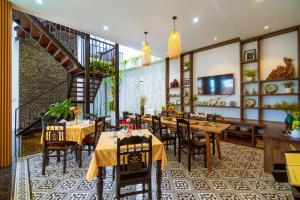 a restaurant with tables and chairs and a staircase at Hoi An Gravel Pool Villa & Spa in Hoi An