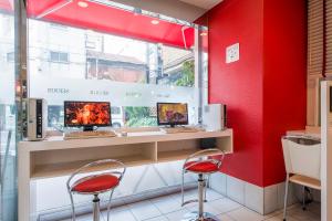 a red room with two desks with two monitors at Sejour Inn Nagarekawa in Hiroshima