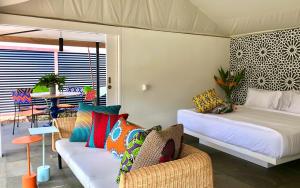 Zimmer mit 2 Betten, einem Sofa und einem Tisch in der Unterkunft Origin Uluwatu in Uluwatu